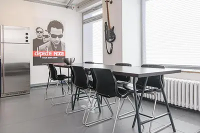 a dining room with a table and chairs and a refrigerator at Hidden Submarine in Vilnius