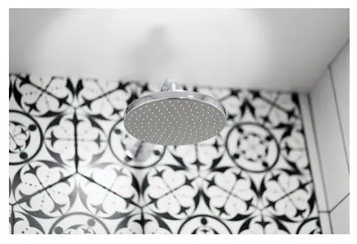 a light in a bathroom with a black and white tiles at Poilsio namelis in Skynimai