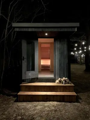 a small house with stairs in a park at night at Beautiful Tiny house on the lake side. in Trakai