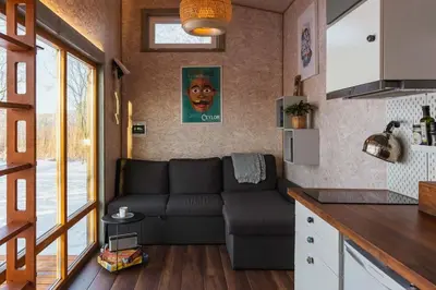 a living room with a couch in a tiny house at Beautiful Tiny house on the lake side. in Trakai
