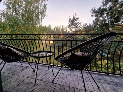 two chairs and a table on a wooden deck at Pirties Spa namas in Molėtai