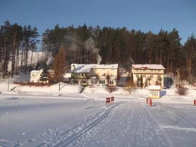 a house in the middle of a snow covered field at Svečių namai ALDAIVITA in Ignalina