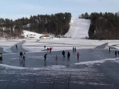 a group of people skating on the ice at a ski slope at Svečių namai ALDAIVITA in Ignalina