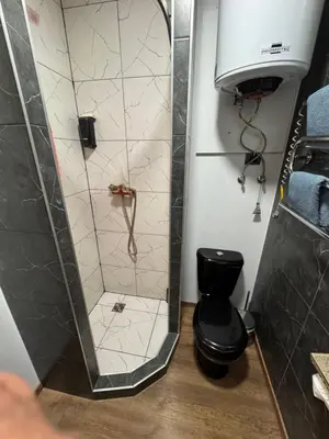 a shower with a black toilet in a bathroom at Apartments in Kaunas in Kaunas