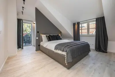 a bedroom with a large bed and large windows at Artsy Exclusive Old Town Residence Gallery Walk in Vilnius