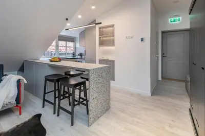 a kitchen with a counter and stools in a room at Artsy Exclusive Old Town Residence Gallery Walk in Vilnius