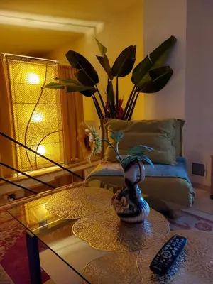 a living room with a glass coffee table with a remote control at Namelis uždarame kieme in Šiauliai