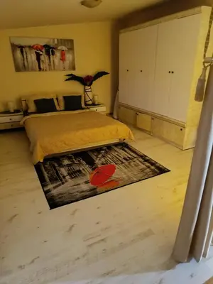 a bedroom with a bed and a rug on the floor at Namelis uždarame kieme in Šiauliai