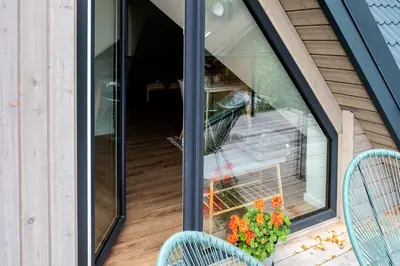 a screened in porch with two chairs and flowers at Vakaras cozy apartment in the guest house with the terrace and the stunning view to the river side in Birštonas
