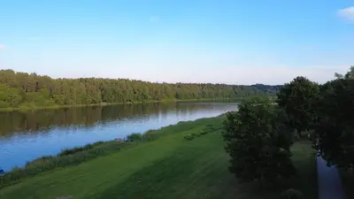 a view of a river with trees and a green field at Vakaras cozy apartment in the guest house with the terrace and the stunning view to the river side in Birštonas