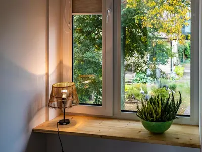 a lamp sitting on a window sill next to a plant at Vakaras cozy apartment in the guest house with the terrace and the stunning view to the river side in Birštonas