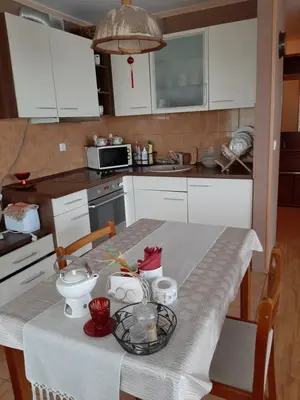 a kitchen with a table with a white table cloth at Neravu namai in Druskininkai