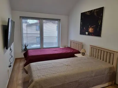 a bedroom with two beds and a window at Neris apartments in Šiauliai