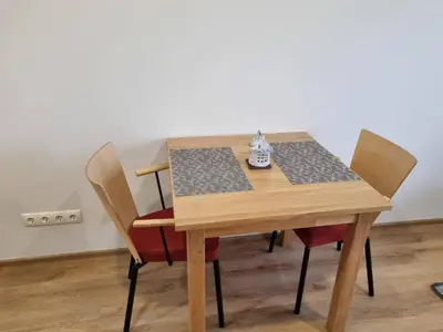 a wooden table with two chairs and a shoe on it at Neris apartments in Šiauliai