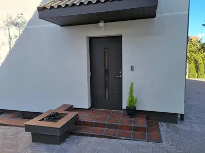a front door of a house with a potted plant at Neris apartments in Šiauliai