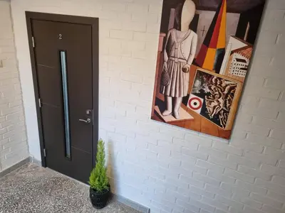 a painting of a woman on a wall next to a door at Neris apartments in Šiauliai