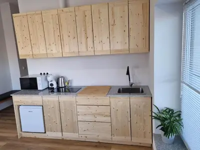 a kitchen with wooden cabinets and a sink at Neris apartments in Šiauliai