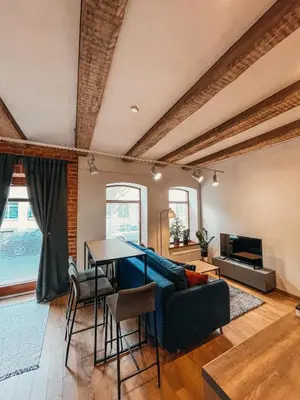 a living room with a blue couch and a table at 1880 Apartment with Private Parking in Marijampolė