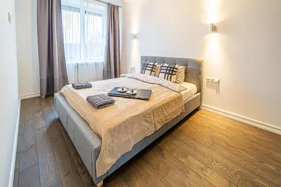 a bedroom with a bed with a tray of food on it at Žalgiris arena apartment with AC in Kaunas