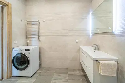 a laundry room with a washing machine and a sink at Žalgiris arena apartment with AC in Kaunas