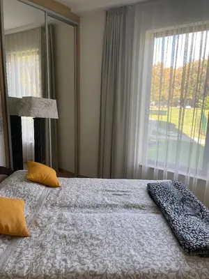 a bedroom with a bed and a large window at Vita Apartment in Druskininkai