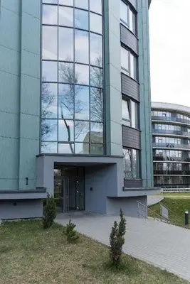 a large building with a tree in front of it at Vita Apartment in Druskininkai