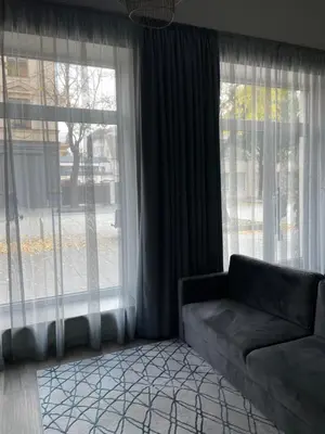 a living room with a couch and large windows at Daukanto 5 in Kaunas