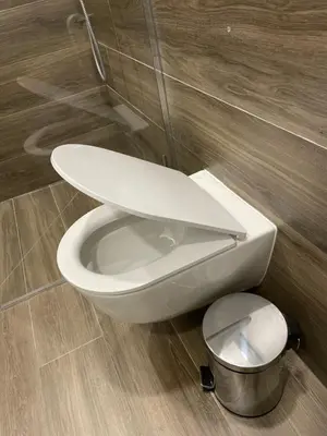 a white toilet in a bathroom with a trash can at Daukanto 5 in Kaunas