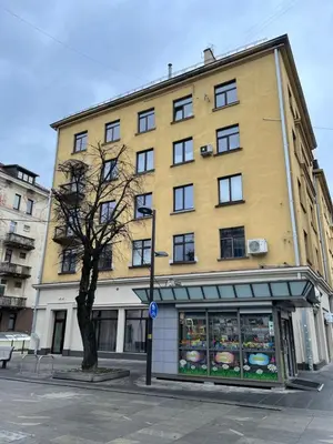 a large yellow building with a tree in front of it at Daukanto 5 in Kaunas