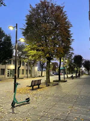 a scooter parked next to a bench in a park at Daukanto 5 in Kaunas