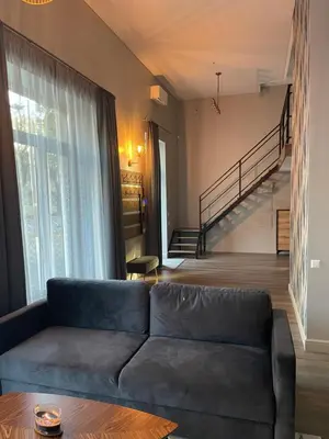 a living room with a couch and a staircase at Daukanto 5 in Kaunas