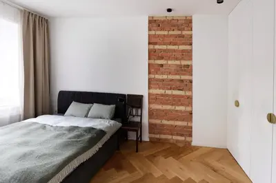 a bedroom with a bed and a brick wall at NEW! WARM and COSY apartment with private ENTRANCE and PARKING in a city center in Vilnius