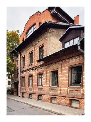 a red brick building with windows on a street at NEW! WARM and COSY apartment with private ENTRANCE and PARKING in a city center in Vilnius