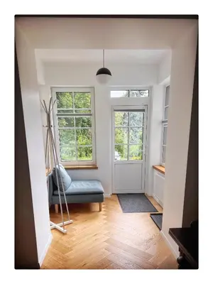 a living room with a blue couch and windows at NEW! WARM and COSY apartment with private ENTRANCE and PARKING in a city center in Vilnius