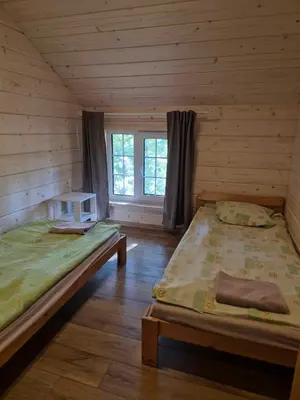 a room with two beds in a log cabin at Bona Natura Pirtelė in GratiÅ¡kÄ—s