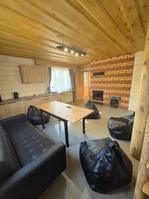 a room with a couch and a table and chairs at Bona Natura Pirtelė in GratiÅ¡kÄ—s