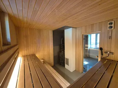 a large wooden room with a wooden floor and a room with at Bona Natura Pirtelė in GratiÅ¡kÄ—s
