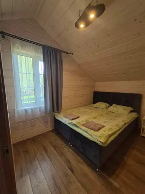 a bedroom with a bed in a room with a window at Bona Natura Pirtelė in GratiÅ¡kÄ—s