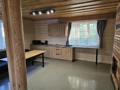 a kitchen with a wooden table and a window at Bona Natura Pirtelė in GratiÅ¡kÄ—s