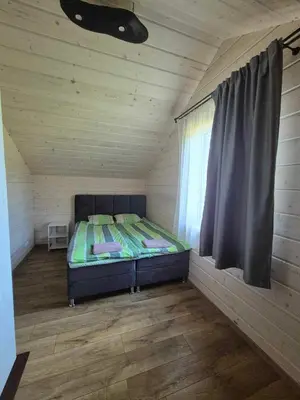 a small bedroom with a bed in a room with a window at Bona Natura Pirtelė in GratiÅ¡kÄ—s