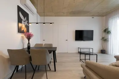 a dining room with a table and chairs and a tv at Bossa Nova - modern 2 bedroom apartment in the center in Vilnius