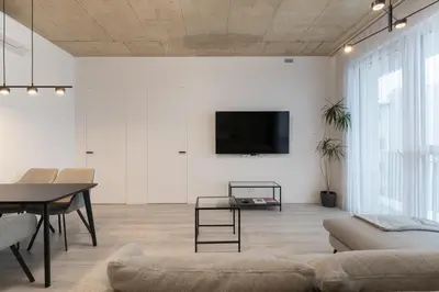 a living room with a flat screen tv on a wall at Bossa Nova - modern 2 bedroom apartment in the center in Vilnius