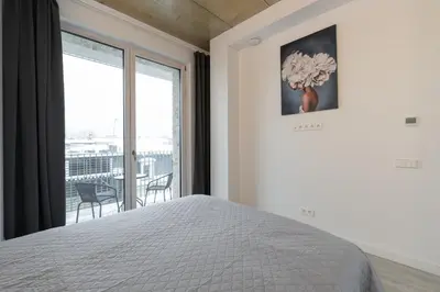 a bedroom with a bed and a large window at Bossa Nova - modern 2 bedroom apartment in the center in Vilnius