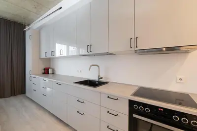 a kitchen with white cabinets and a sink at Bossa Nova - modern 2 bedroom apartment in the center in Vilnius