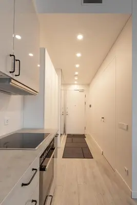 a kitchen with white cabinets and a long hallway at Bossa Nova - modern 2 bedroom apartment in the center in Vilnius