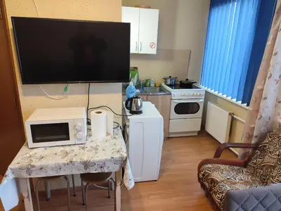 a small kitchen with a table with a television on it at ITAJA apartment in Šiauliai