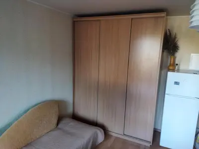 a kitchen with a cabinet and a refrigerator at ITAJA apartment in Šiauliai