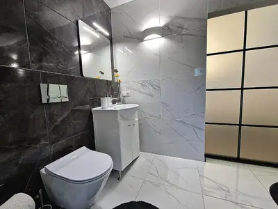 a bathroom with a white toilet and a sink at Seliu 25 Homestay Apartment poilsio namai in Šiauliai