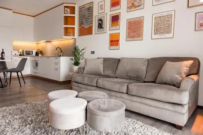 a living room with a couch and a table and a kitchen at Bright Kaunas apartment with Castle view in Kaunas