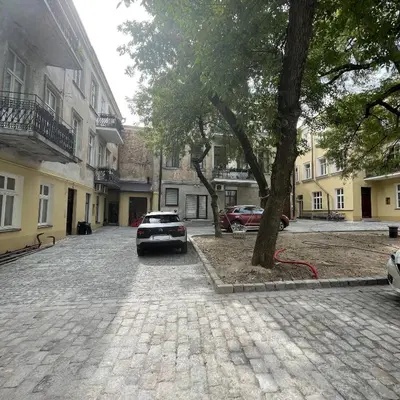 a car parked next to a tree on a street at Modern Vilnius Old Town apartment with free parking in Vilnius